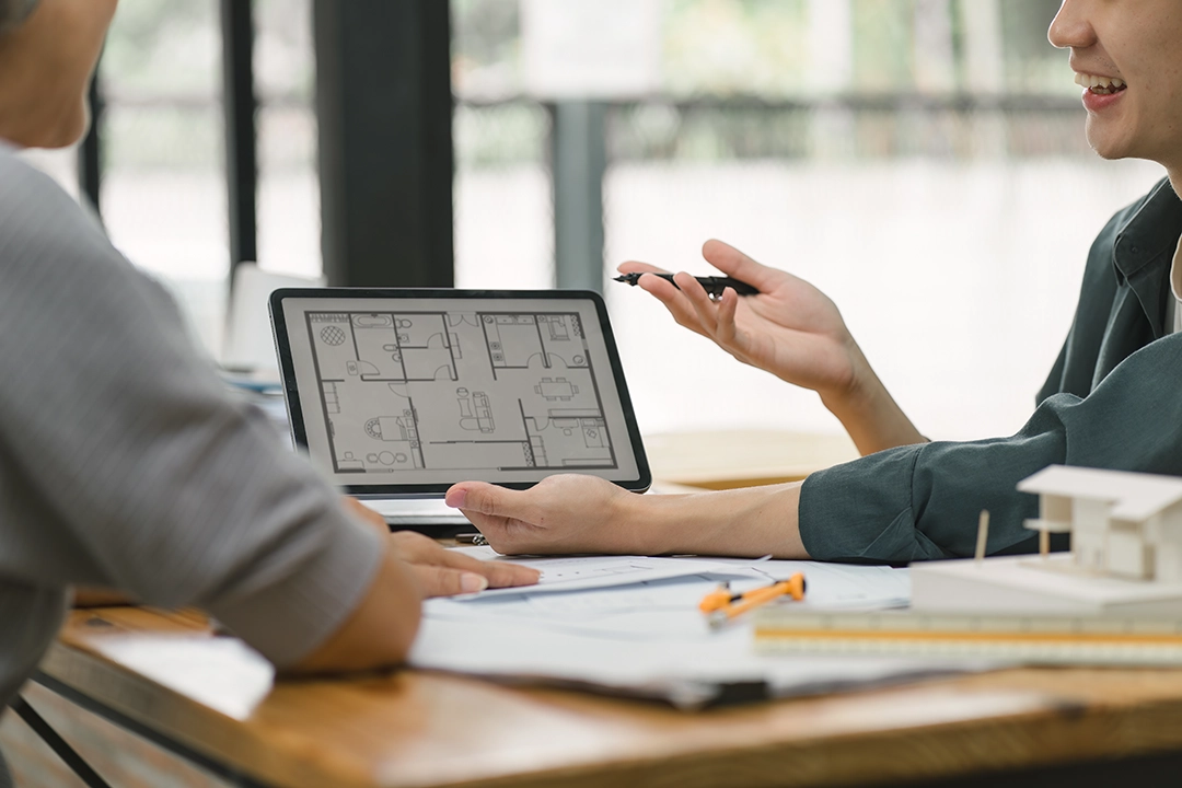 Two people discussing a renovation with a computer demonstation